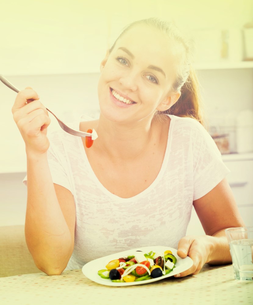 Νεαρή γυναίκα τρώει σαλάτα