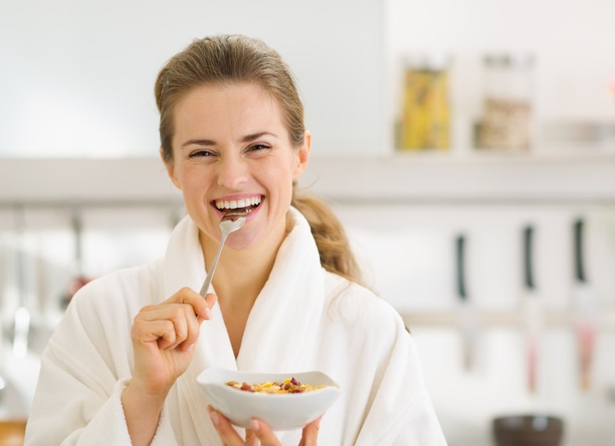 Γυναίκα χαμογελαστή τρώει πρωινό με βρώμη και δημητριακά