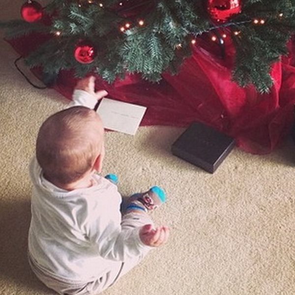 Ο μπέμπης πήρε θέση κάτω από το χριστουγεννιάτικο δέντρο περιμένοντας το δώρο του 