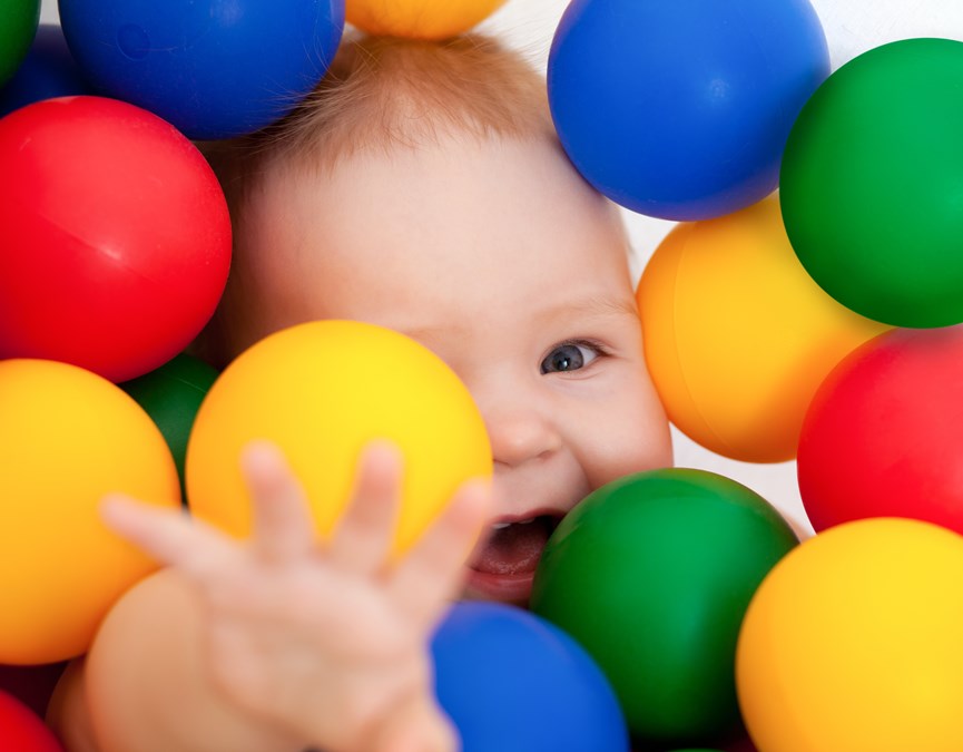 Μωρό παίζει με πολύχρωμες μπάλες