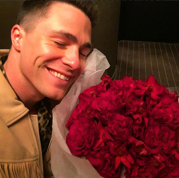 O Colton Haynes κρατάει μια ανθοδέσμη με κόκκινα τριαντάφυλλα
