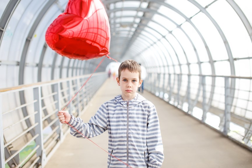 Ένα αγόρι που κρατάει ένα μπαλόνι σε σχήμα καρδιάς