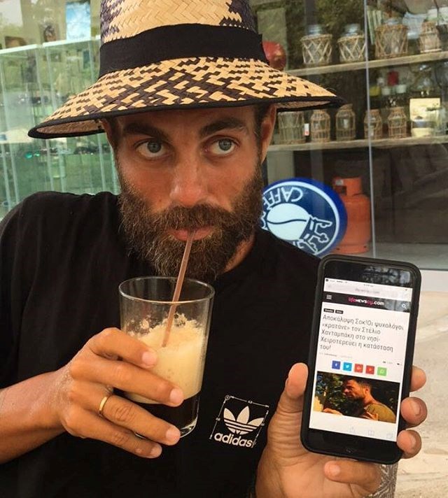 Ο Στέλιος Χανταμπάκης δείχνει ψευδές δημοσίευμα στον φακό, πίνοντας τον καφέ του στον Άγιο Δομίνικο